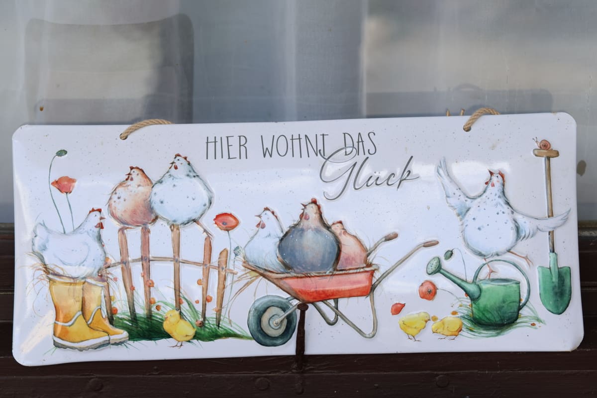 Schild am Hof mit der Aufschrift „Hier wohnt das Glück“